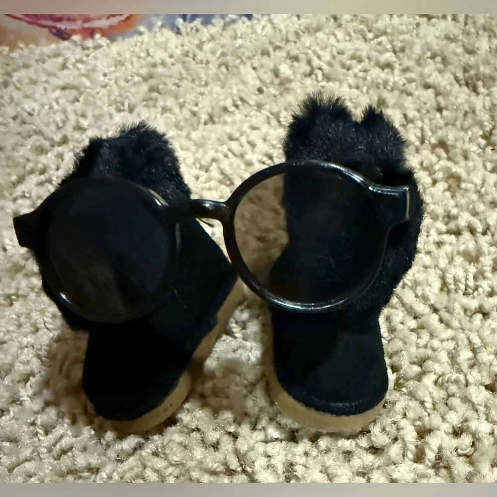 Labubu accessories: black shearling boot with zipper, and black glasses