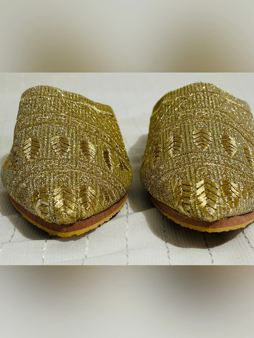 Moroccan babouche slippers adorned with intricate embroidery and a pointed toe.