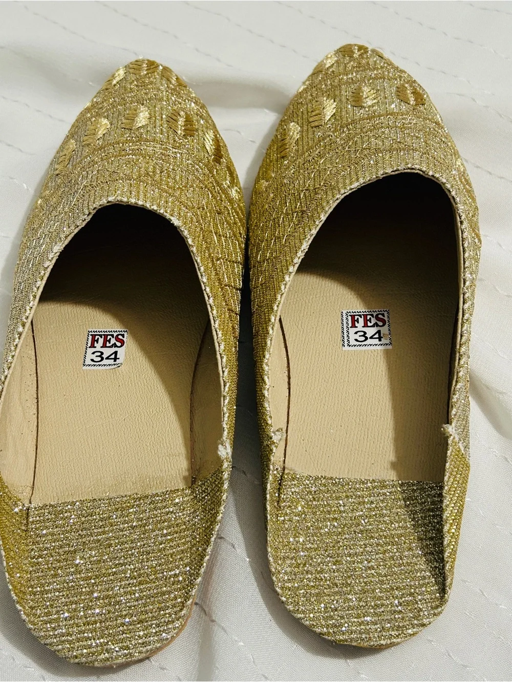 Moroccan babouche slippers adorned with intricate embroidery and a pointed toe.