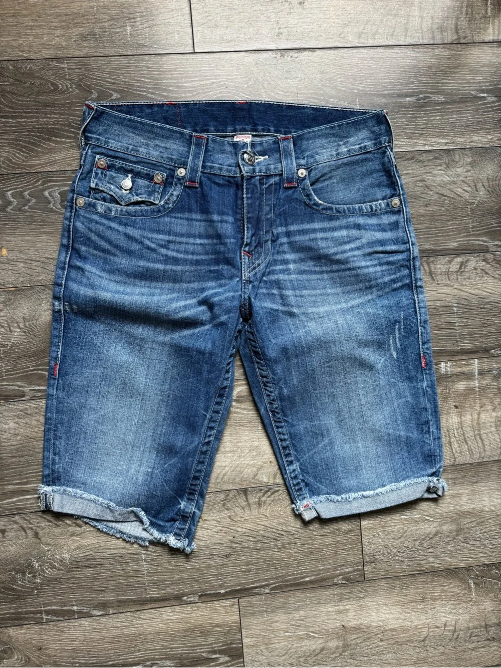 True Religion medium blue denim cutoff shorts with red logo patch