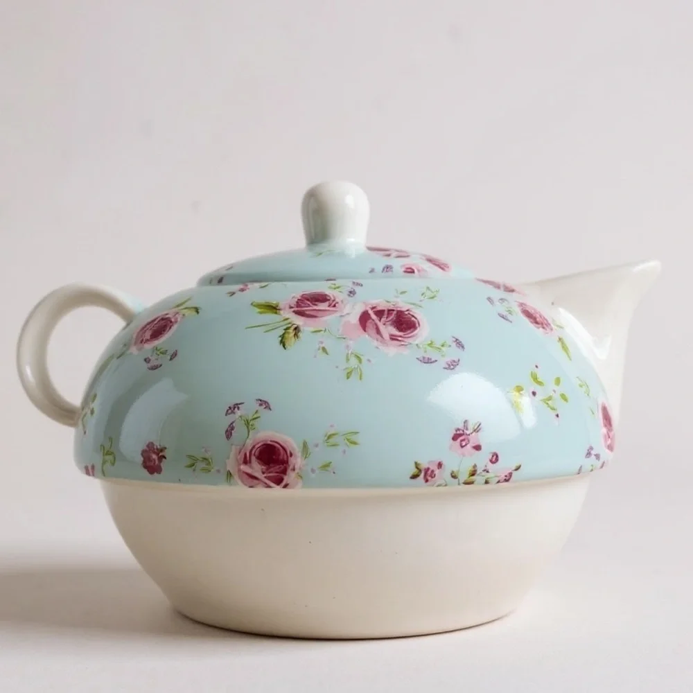 Small teapot with it’s own cup, charming, blue with roses, no flaws