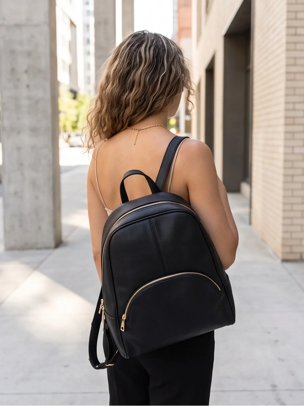 Minimalist Black Pebbled Leather Backpack with Gold Hardware